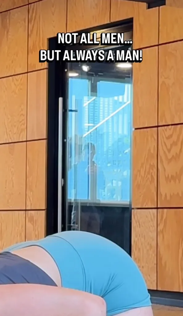 A person exercising on the floor, with their back facing the camera, while a man is visible through a glass door in the background.