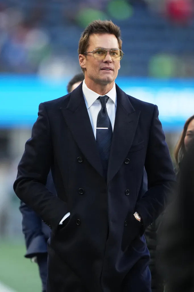 Former NFL player Tom Brady walking on the field.