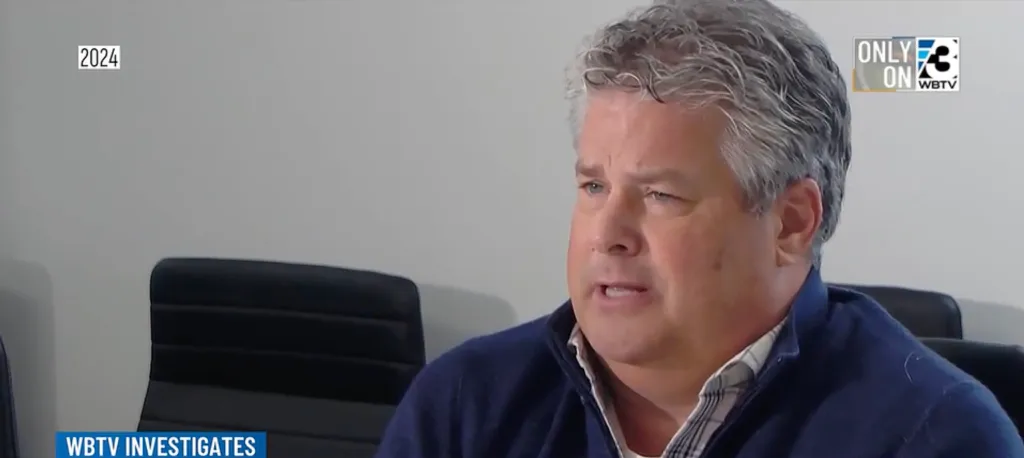 Jeff Noble, a man with graying hair and a navy blue sweater, speaking.