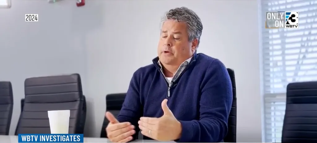 Jeff Noble, a man with gray hair, speaks during an interview while seated at a conference table.