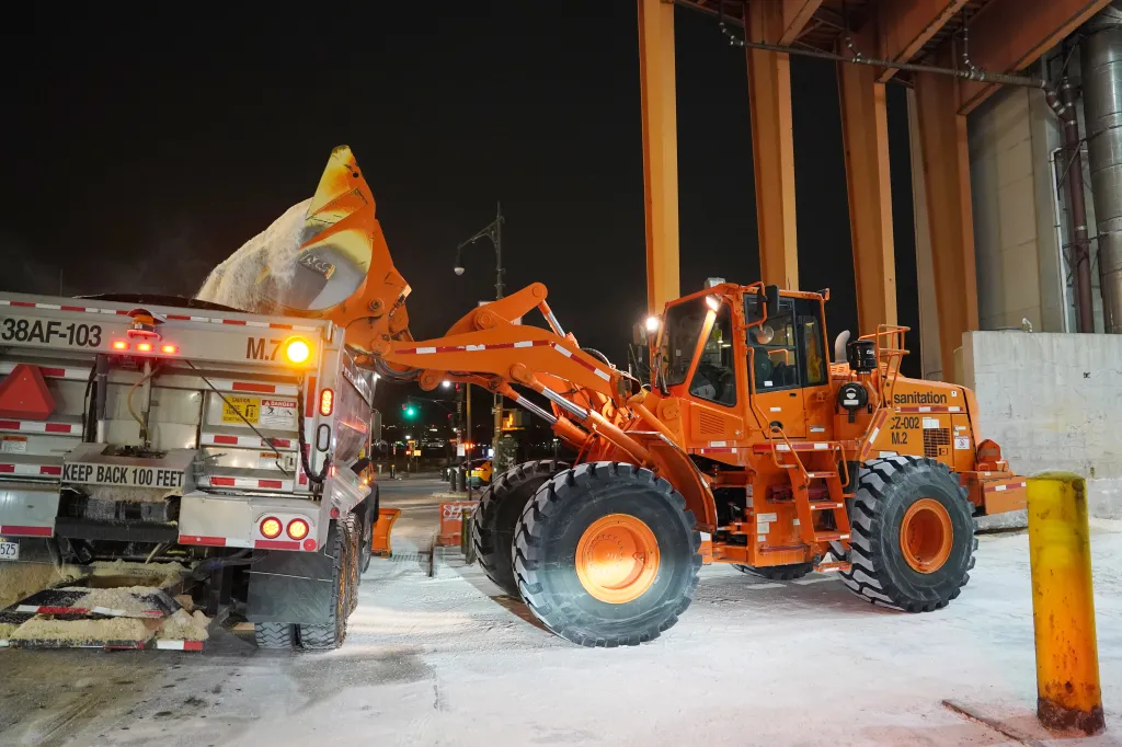 A front-end loader loads salt into a NYC snow plow ahead of a winter storm at the NYC Department of Sanitation salt depot in New York.