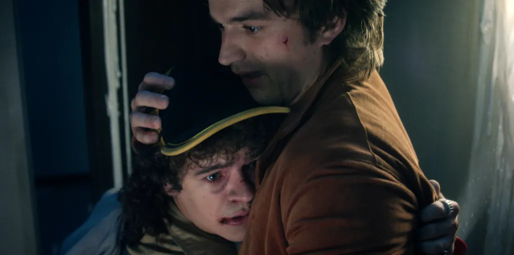 Gaten Matarazzo and Joe Keery hugging in 