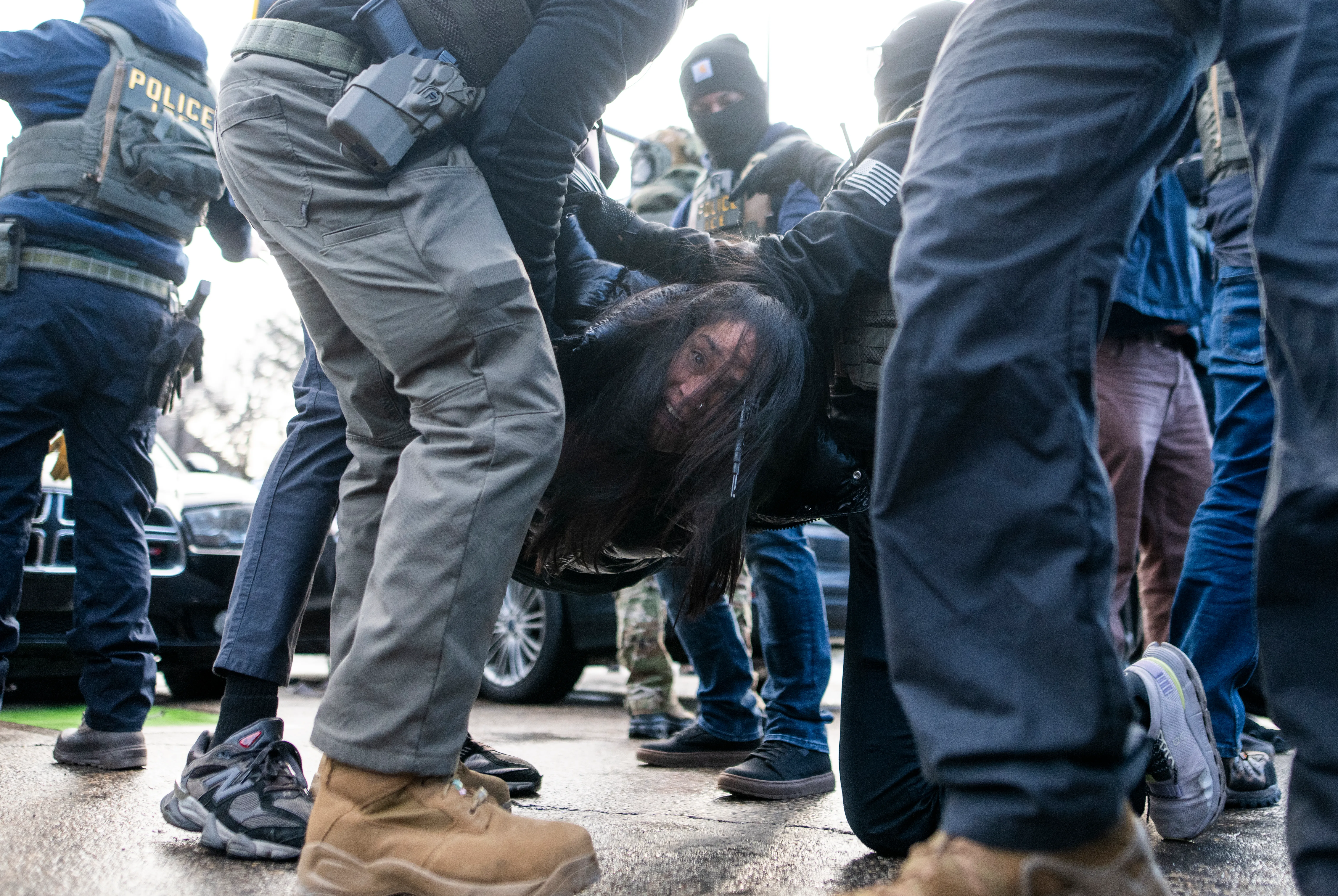 ICE agents detaining a woman