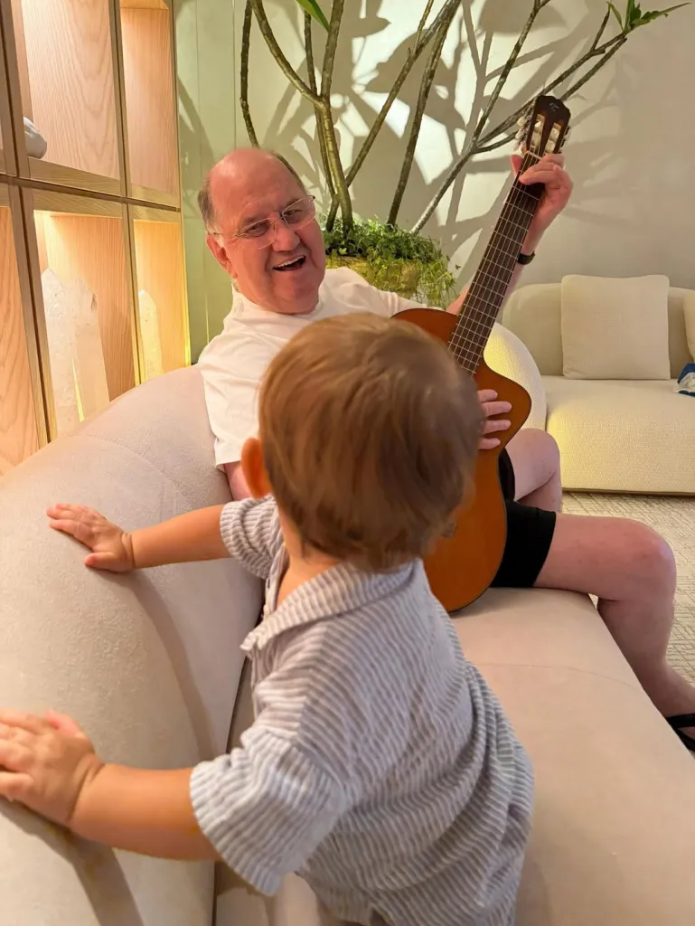 A man playing guitar for a toddler.