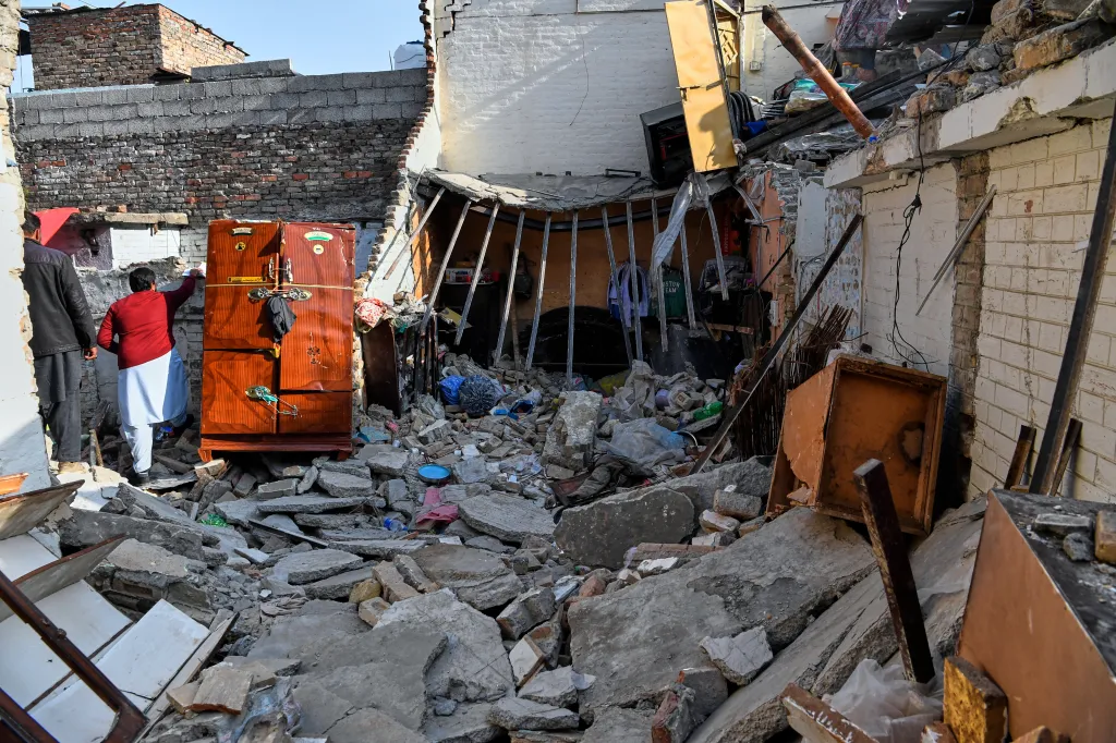 Government officials survey the damage of a home caused by a gas cylinder explosion hours after a wedding reception, in Islamabad, Pakistan, Sunday, Jan. 11, 2026.