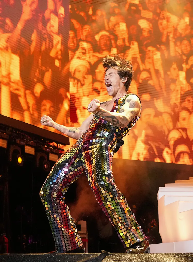 Harry Styles performs onstage at Coachella in a colorful sequined jumpsuit.
