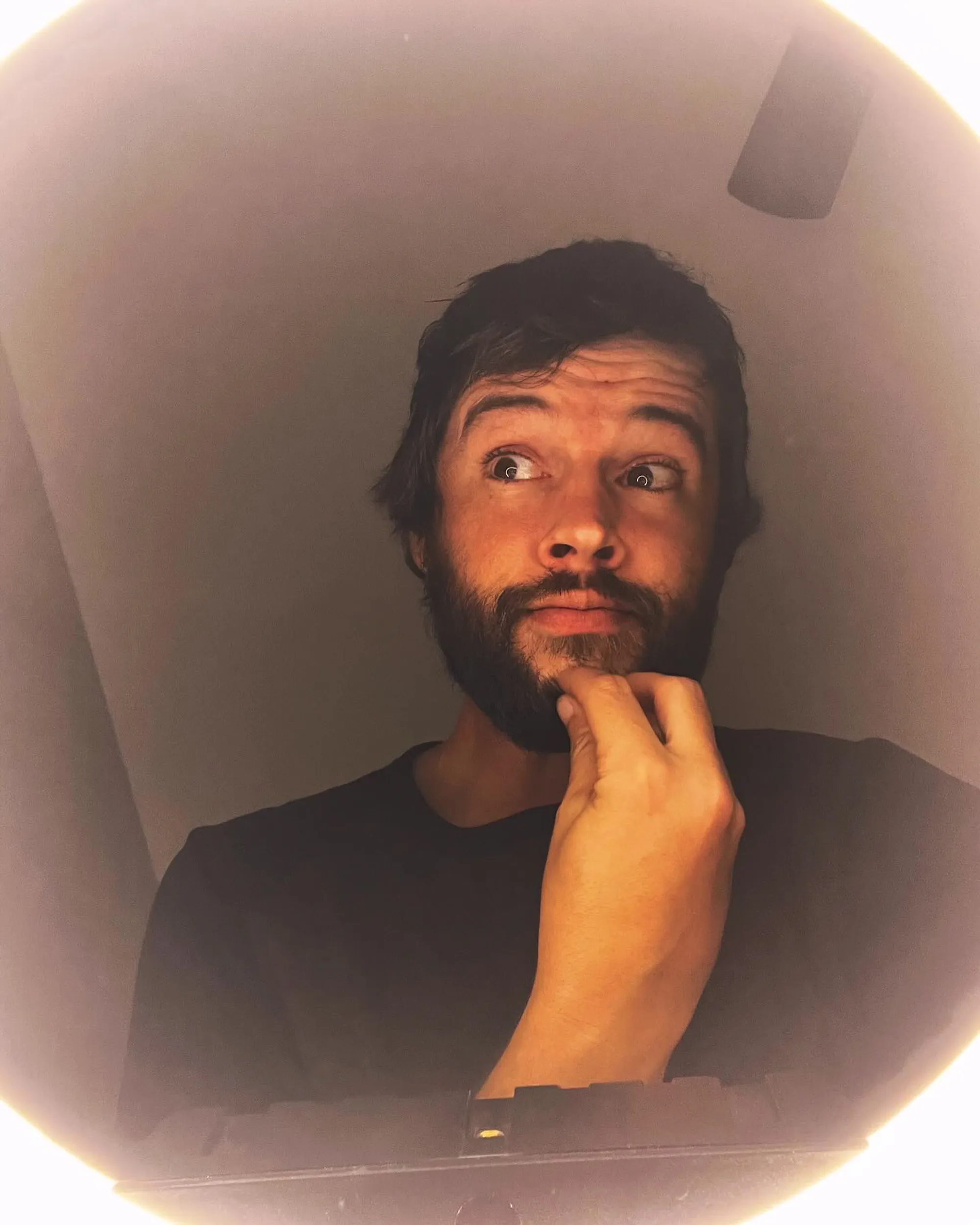 Matt Prokop with a beard and dark hair, looking up and to the right with his hand on his chin.