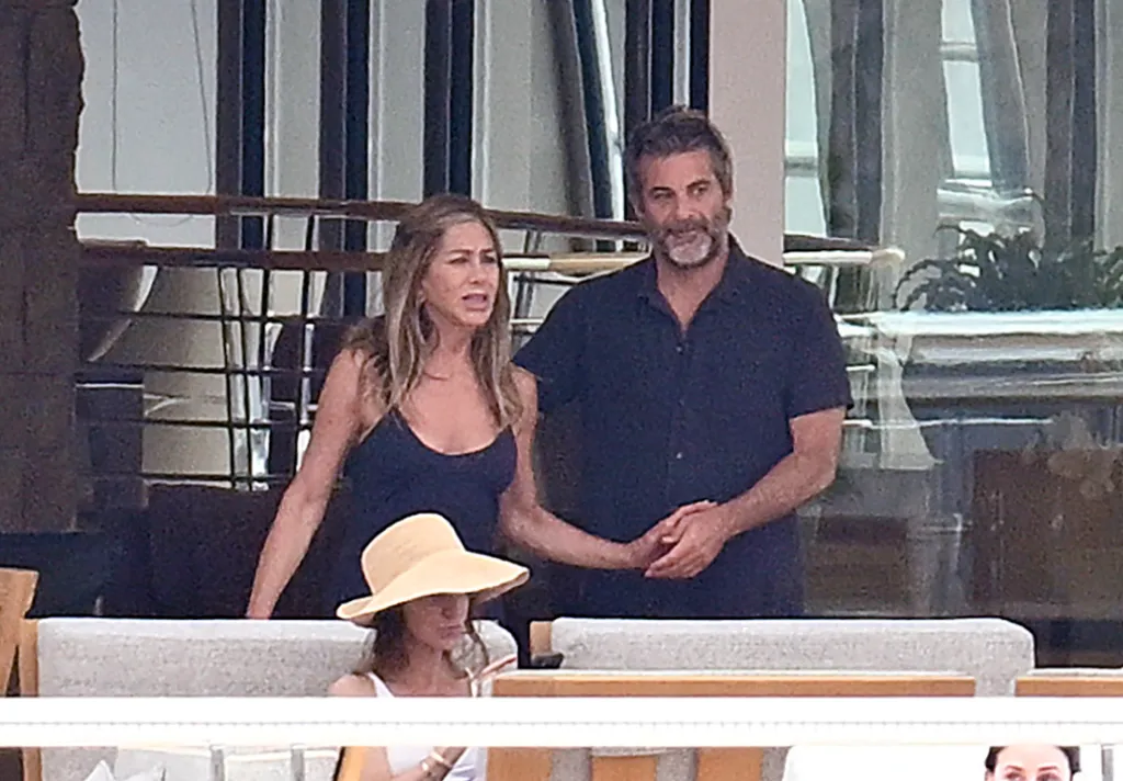 Jennifer Aniston and Jim Curtis standing on the yacht Rising Sun in Mallorca.
