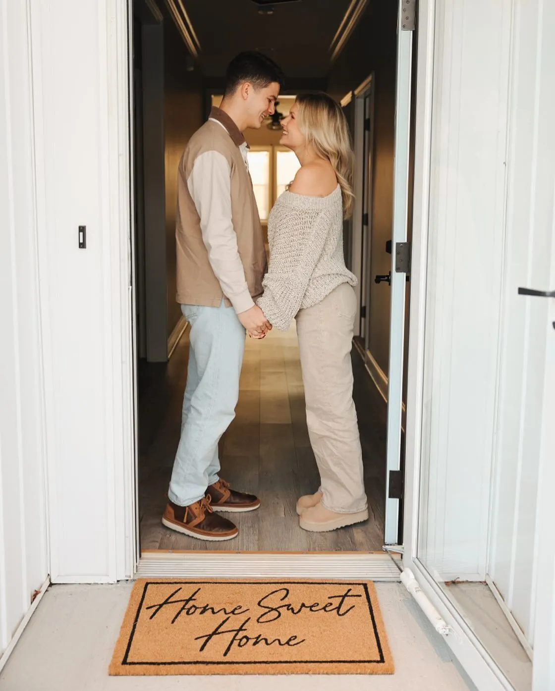 Katie Bates and Travis Clark holding hands in their new home.