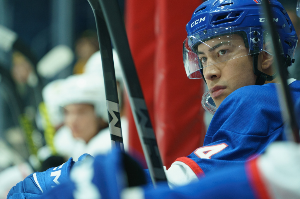 Shane Hollander in a hockey uniform, wearing a blue helmet and jersey.