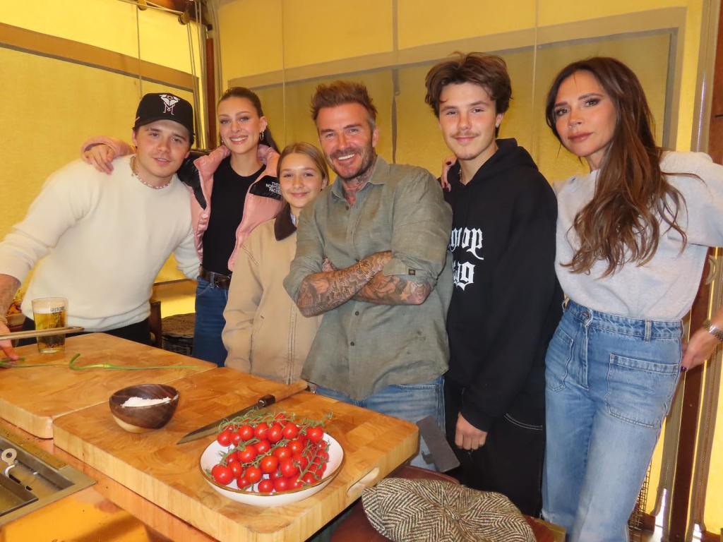 Brooklyn Beckham and family posing in a kitchen.