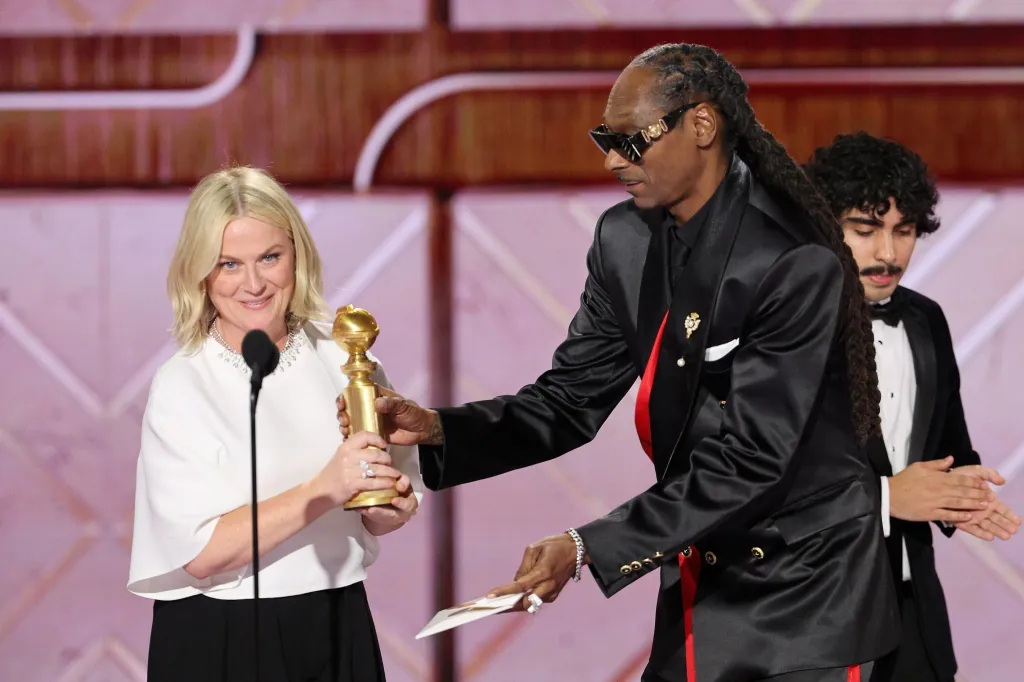 Amy Poehler, left, accepting the award for best podcast for 