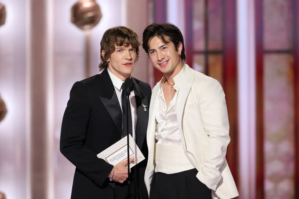 Connor Storrie and Hudson Williams presenting an award at the 83rd Golden Globes.
