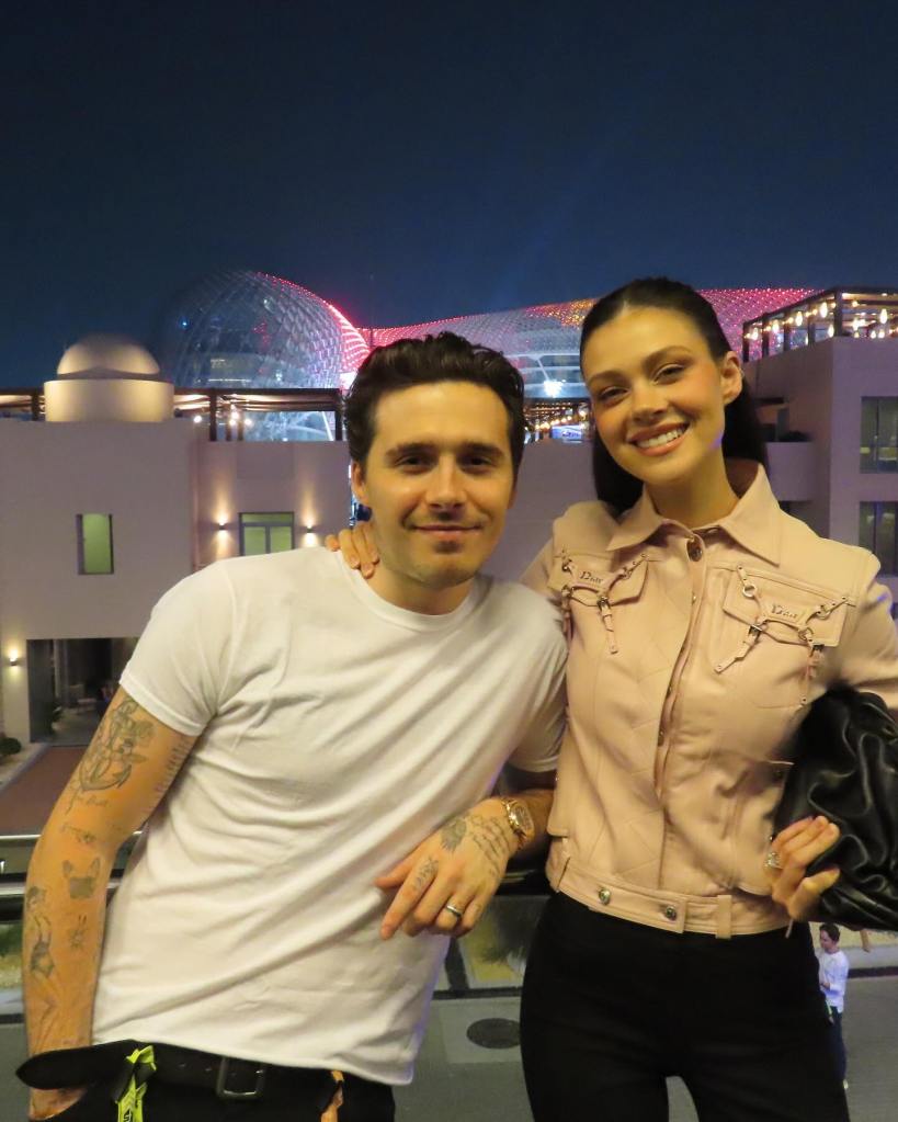 Brooklyn Beckham and Nicola Peltz smiling outdoors in Abu Dhabi.