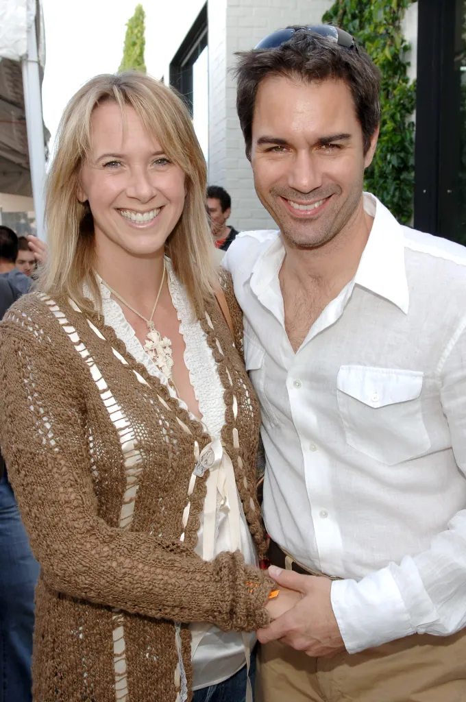 Eric McCormack and wife Janet McCormack smiling and holding hands.
