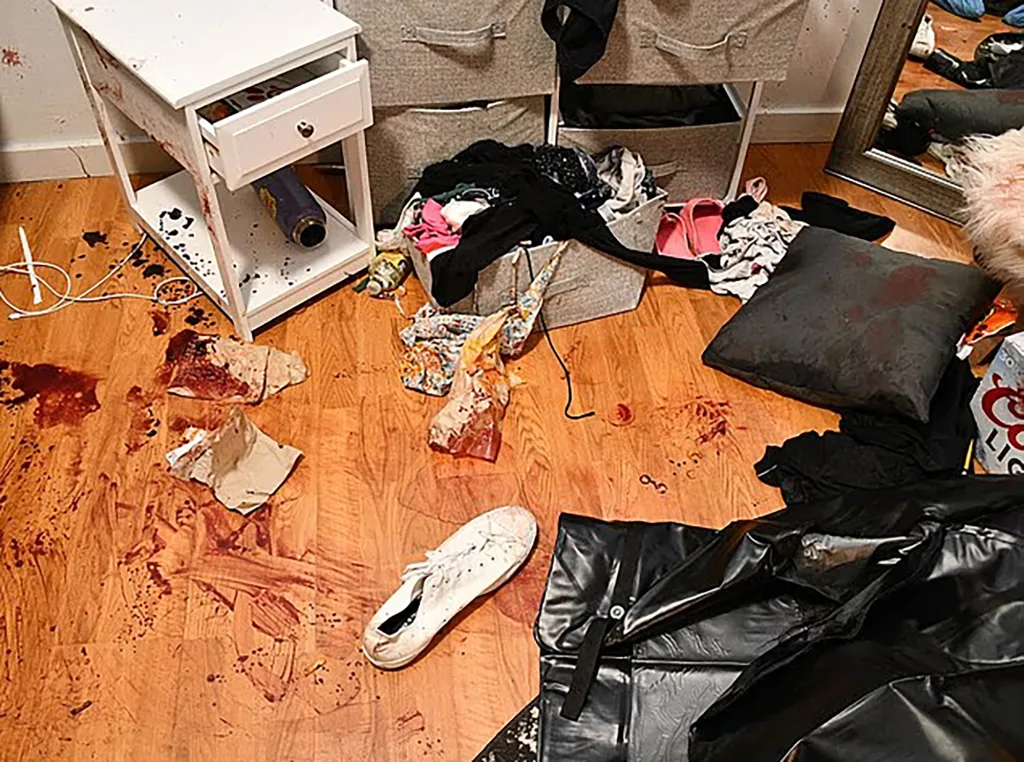 Blood stains the wood floor, clothing and furniture inside one of the bedrooms of the off-campus house.