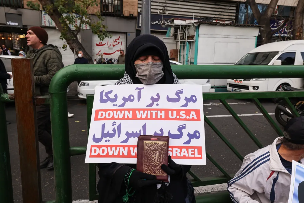 An Iranian woman holding a placard that says 