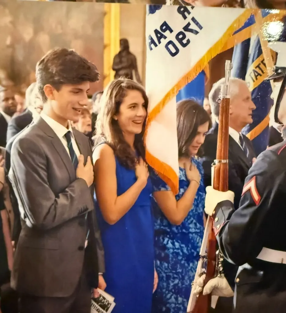 Jack Schlossberg and Tatiana Schlossberg with another woman, all three with their hands over their hearts.