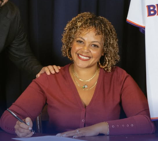Jahmila Edwards signing documents.