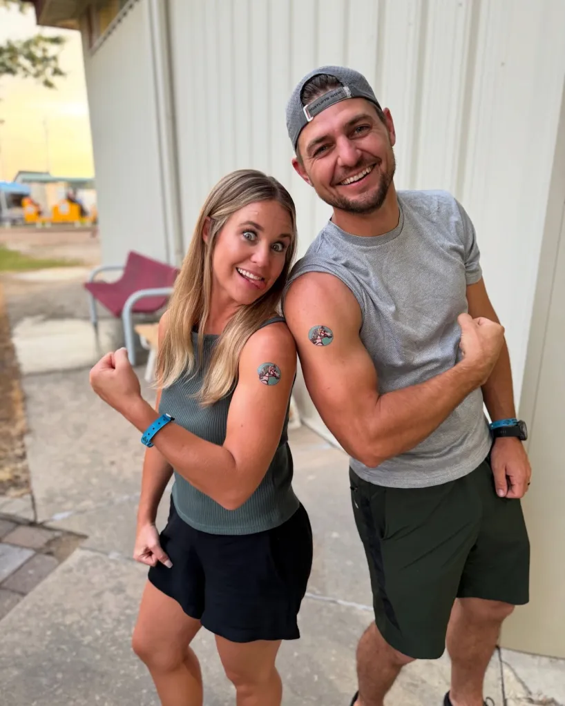 Jana Duggar and Stephen Wissmann posing with flexed biceps and temporary horse tattoos.