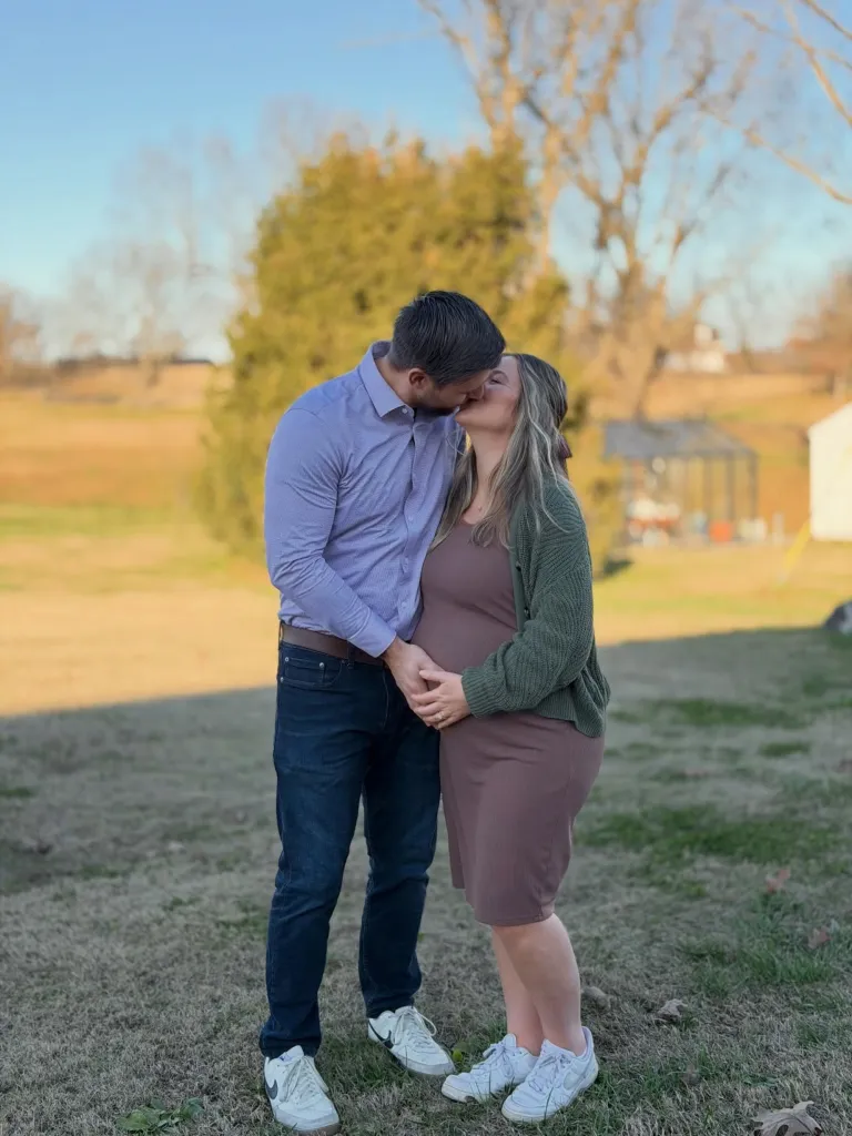 Jana Duggar and Stephen Wissmann kissing, with her hands cradling her pregnant belly.