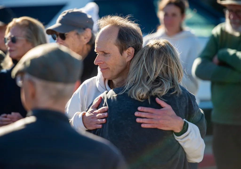 Jean-Francois Vanreusel hugs a woman at a memorial for his wife, Erica Fox.