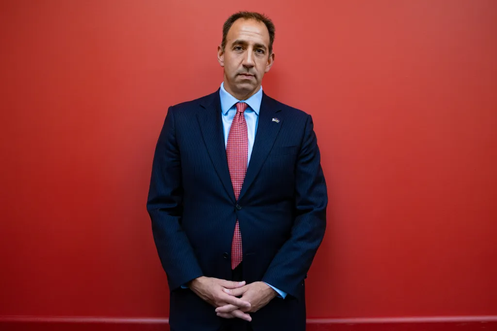 Jeff Bartos, U.S. Republican Senate candidate for Pennsylvania, posing for a portrait against a red wall.