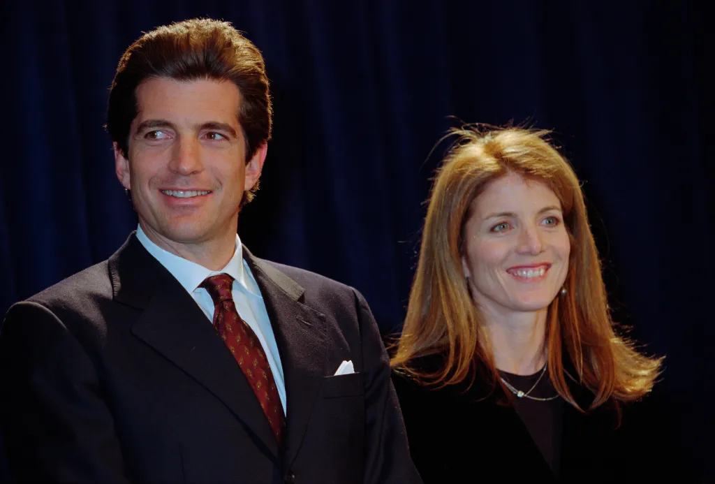 John F. Kennedy Jr. and his sister Caroline Kennedy smiling at an event.