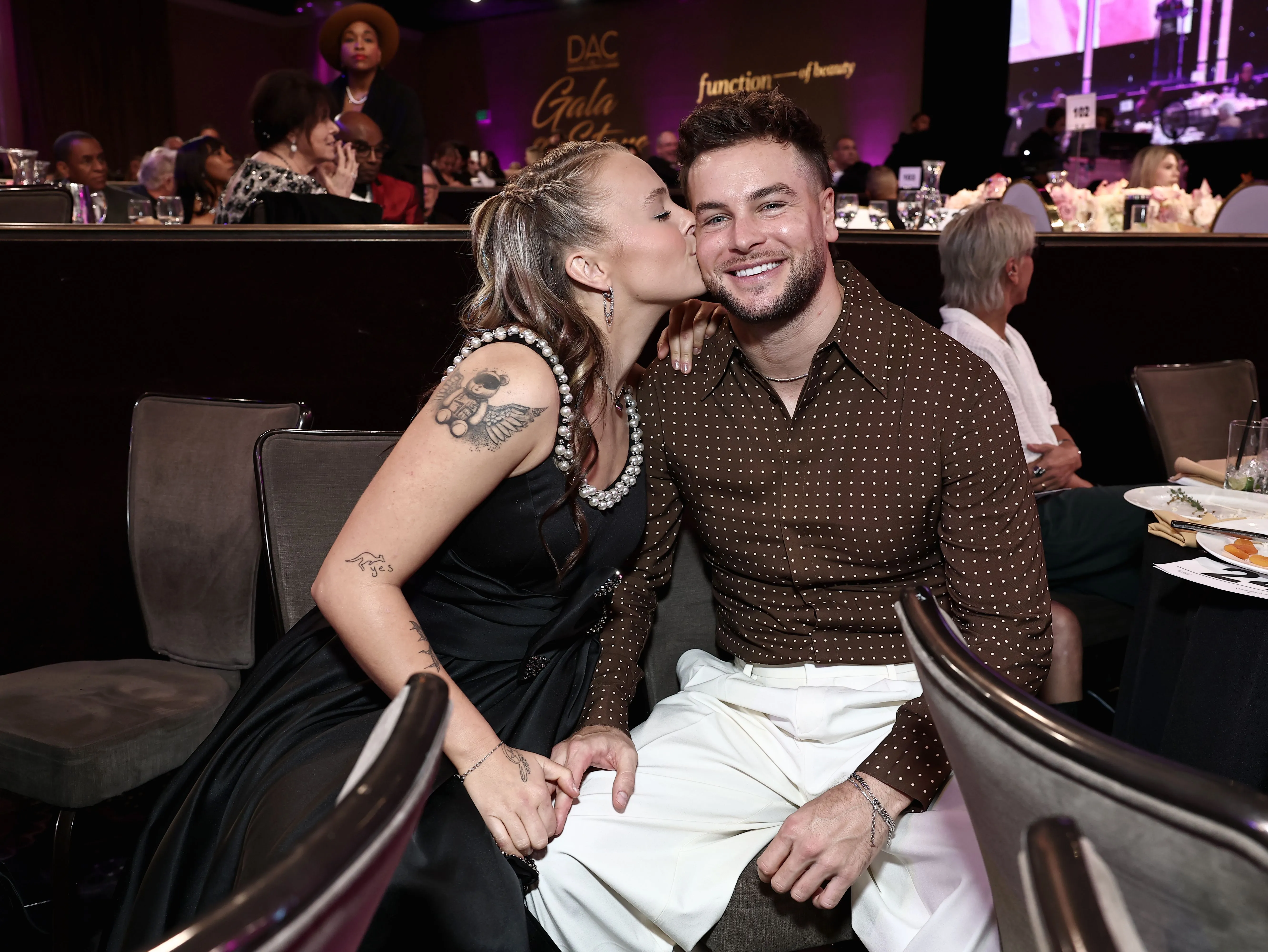 JoJo Siwa plants a kiss on boyfriend Chris Hughes. 