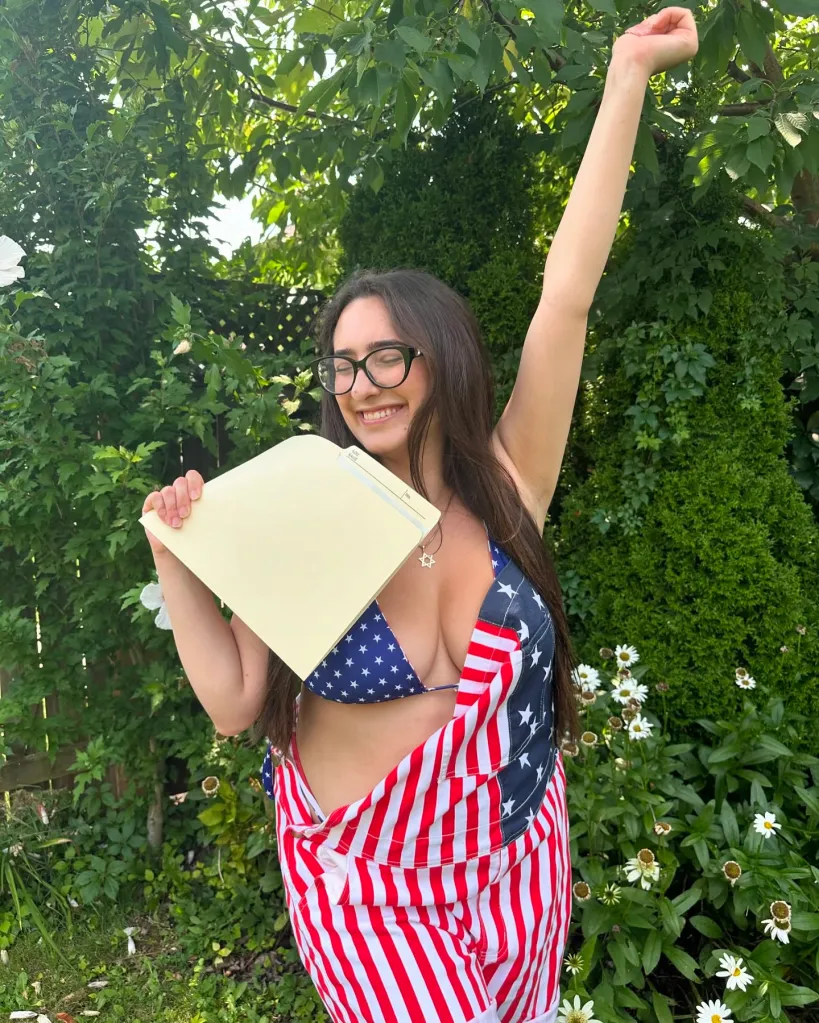 Julia Ain in a social media photo wearing a stars and stripes bikini and holding a file.