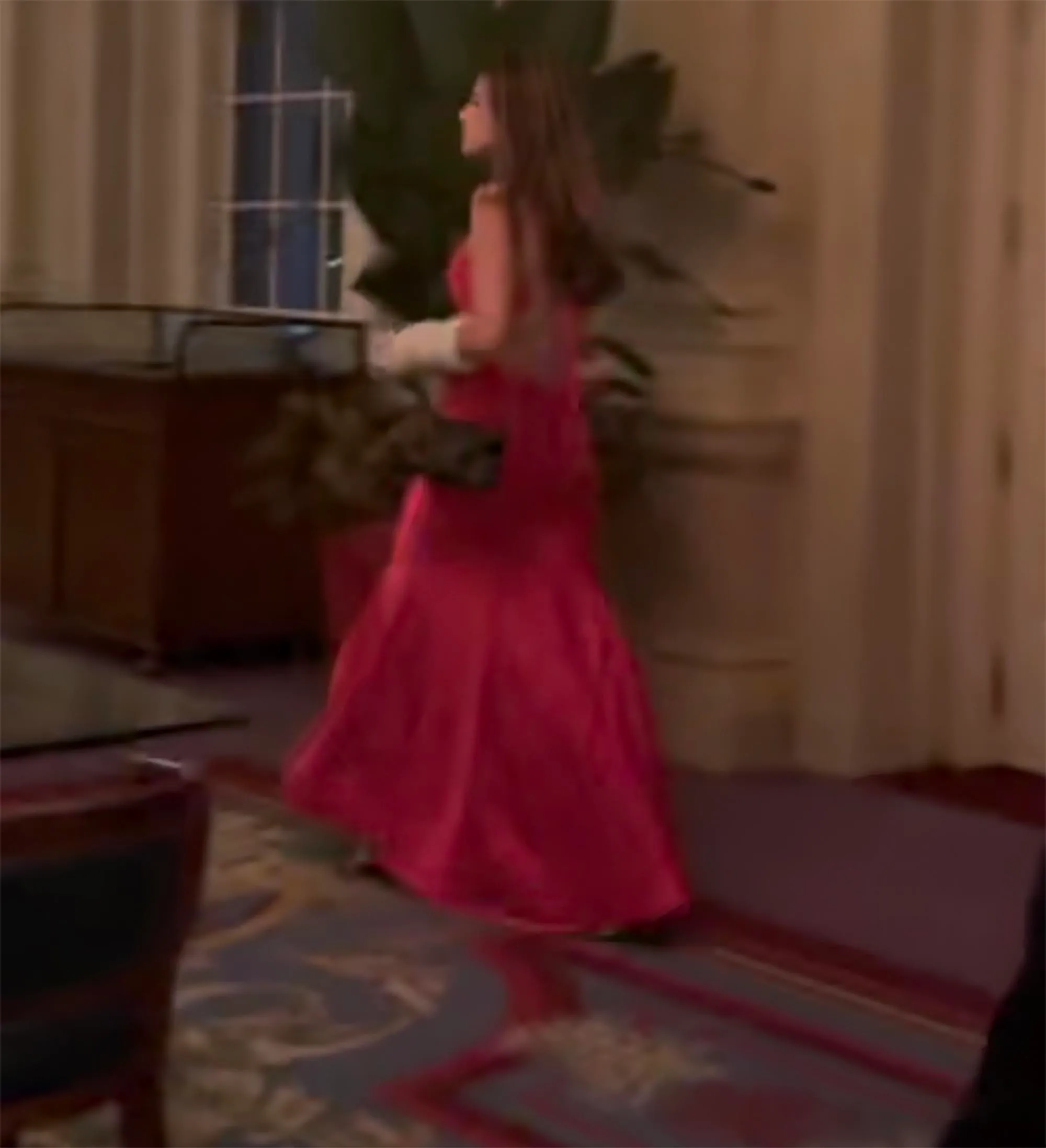Kai Trump in a red silk cutout dress at Tiger Woods' 50th birthday party.
