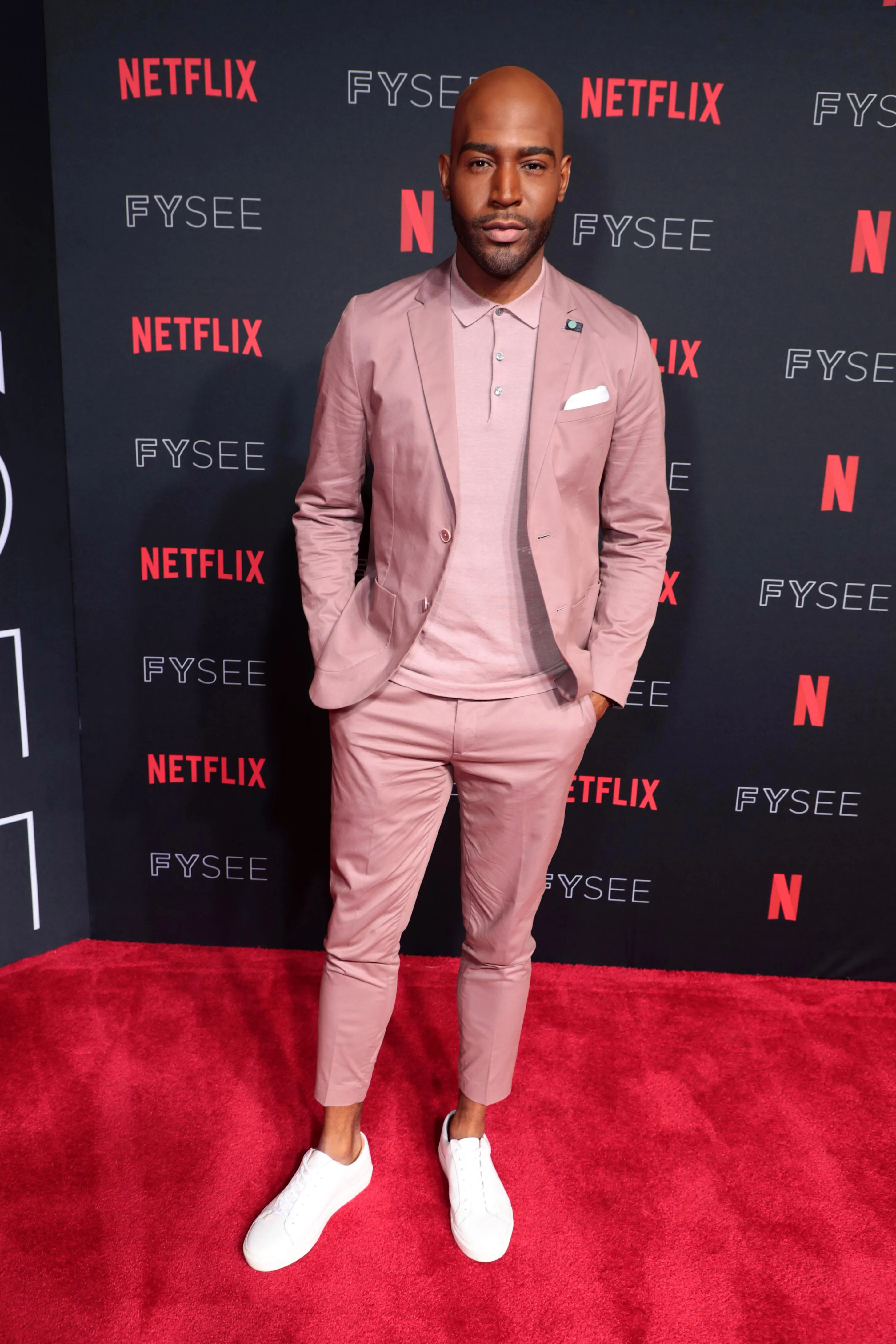 Karamo Brown poses on a red carpet at the Netflix FYSEE Queer Eye Panel event.