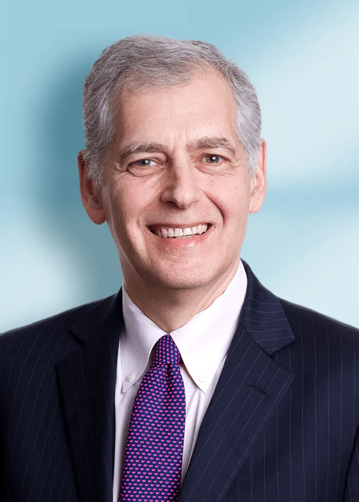 David Karnovsky, a man with gray hair, smiling and wearing a pinstriped suit with a pink and blue patterned tie.