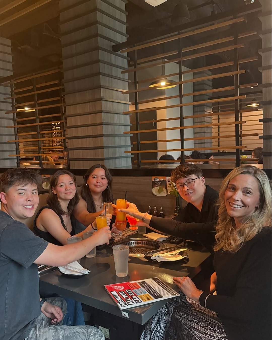 Kate Gosselin and four of her children toast with drinks at a restaurant.