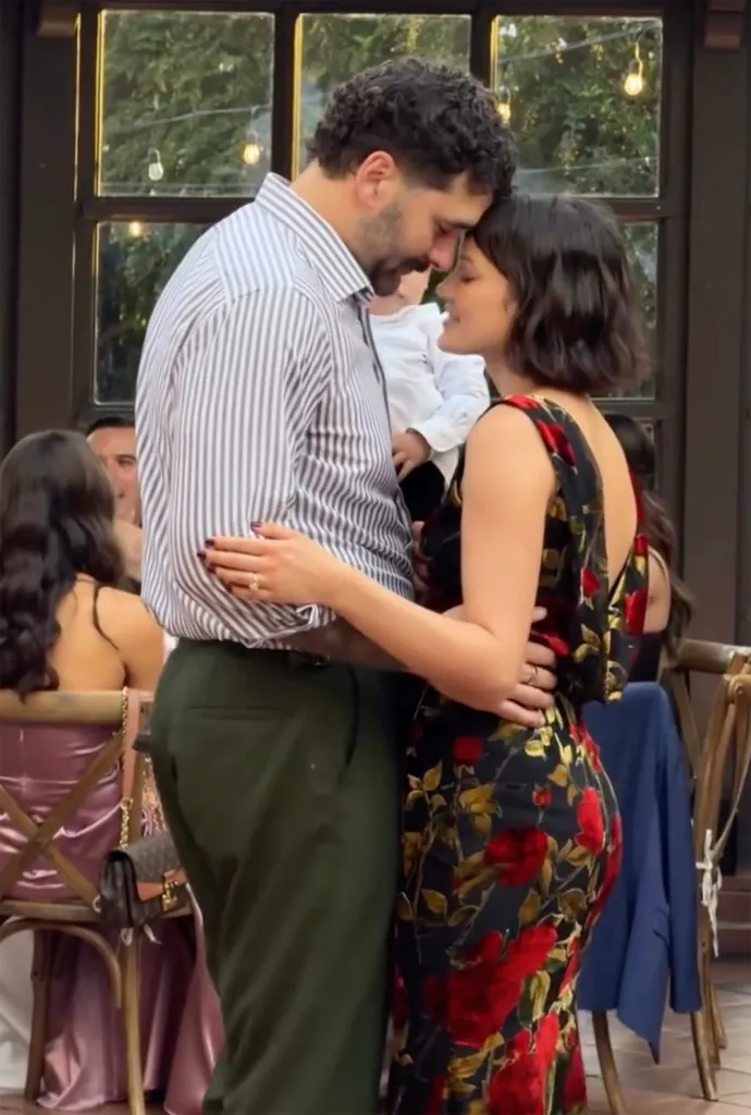 Keilani Asmus and Matt Kalil embracing, with Asmus in a black floral dress and Kalil in a striped shirt and green pants.