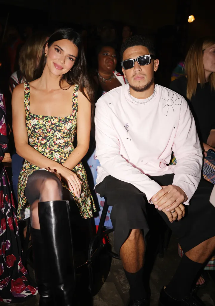 Kendall Jenner in a floral dress and Devin Booker in a pink shirt with sunglasses, sitting at the Marni Spring 2023 front row.