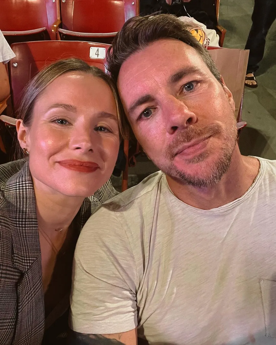 Kristin Bell and Dax Shepard posing for a selfie in an arena.