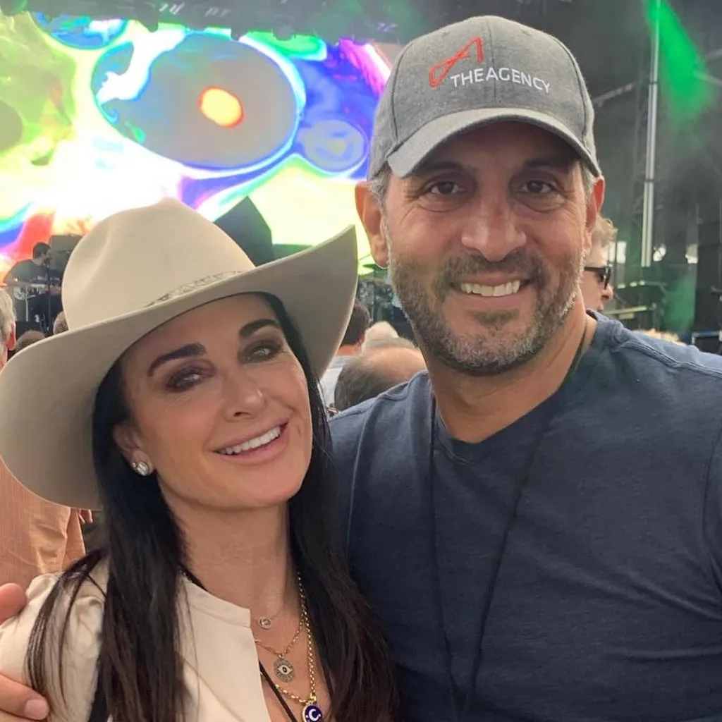 Kyle Richards wearing a cowboy hat and Mauricio Umansky wearing a baseball cap with 