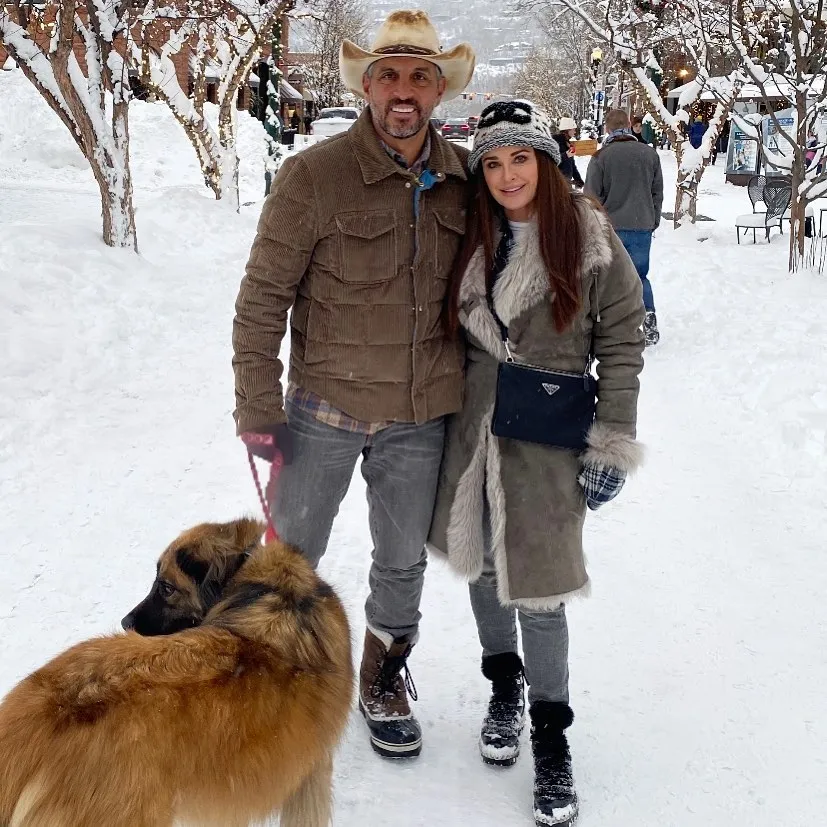 Kyle Richards and Mauricio Umansky posing with their dog in the snow.