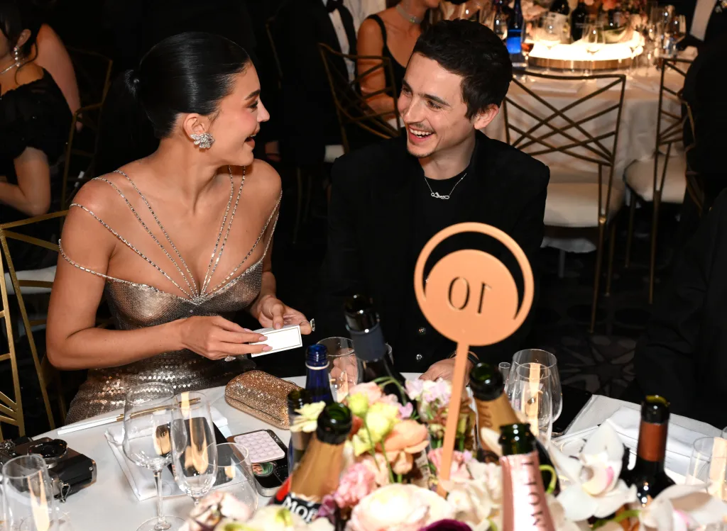 Kylie Jenner and Timothée Chalamet sitting at a table during the 83rd Annual Golden Globe Awards.
