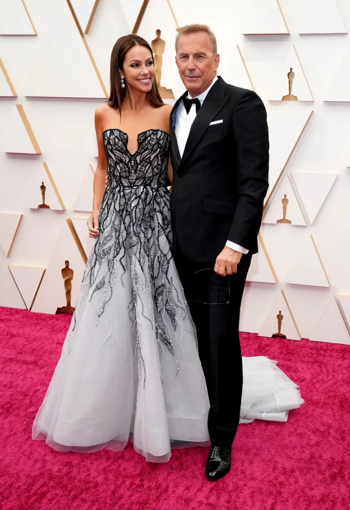 Christine Baumgartner and Kevin Costner pose on the red carpet at the 94th Annual Academy Awards.