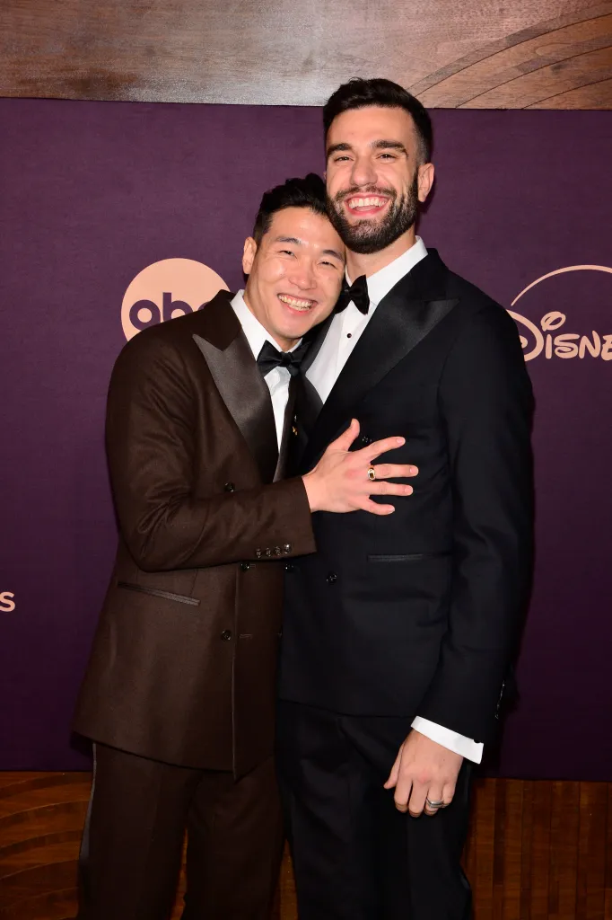 Joel Kim Booster and John Michael Sudsina embracing.