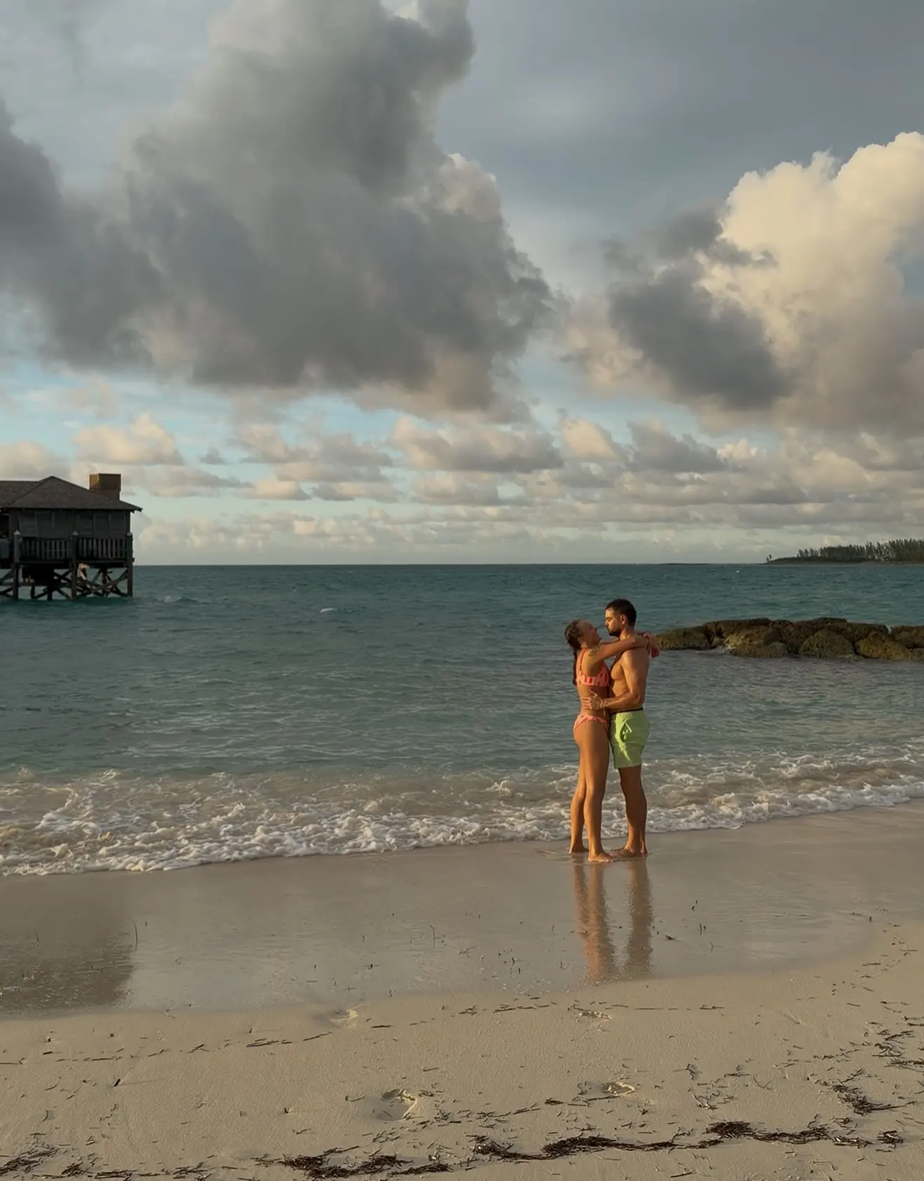 JoJo Siwa and Chris Hughes share a moment on the beach. 