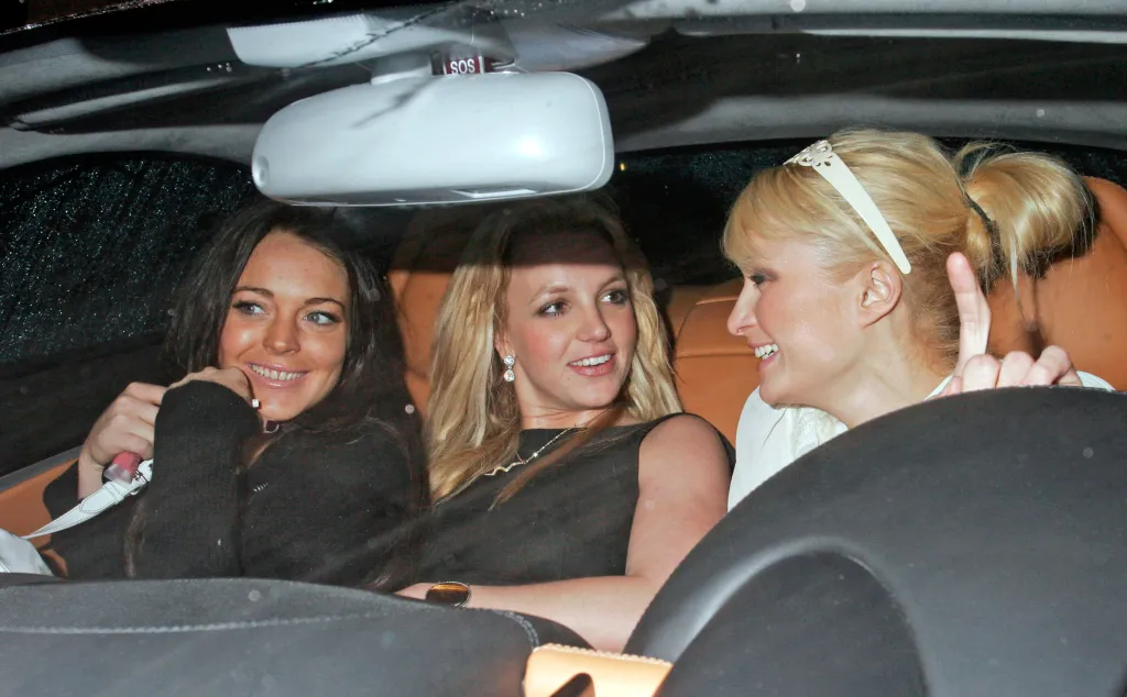 Lindsay Lohan, Britney Spears, and Paris Hilton smiling in a car.