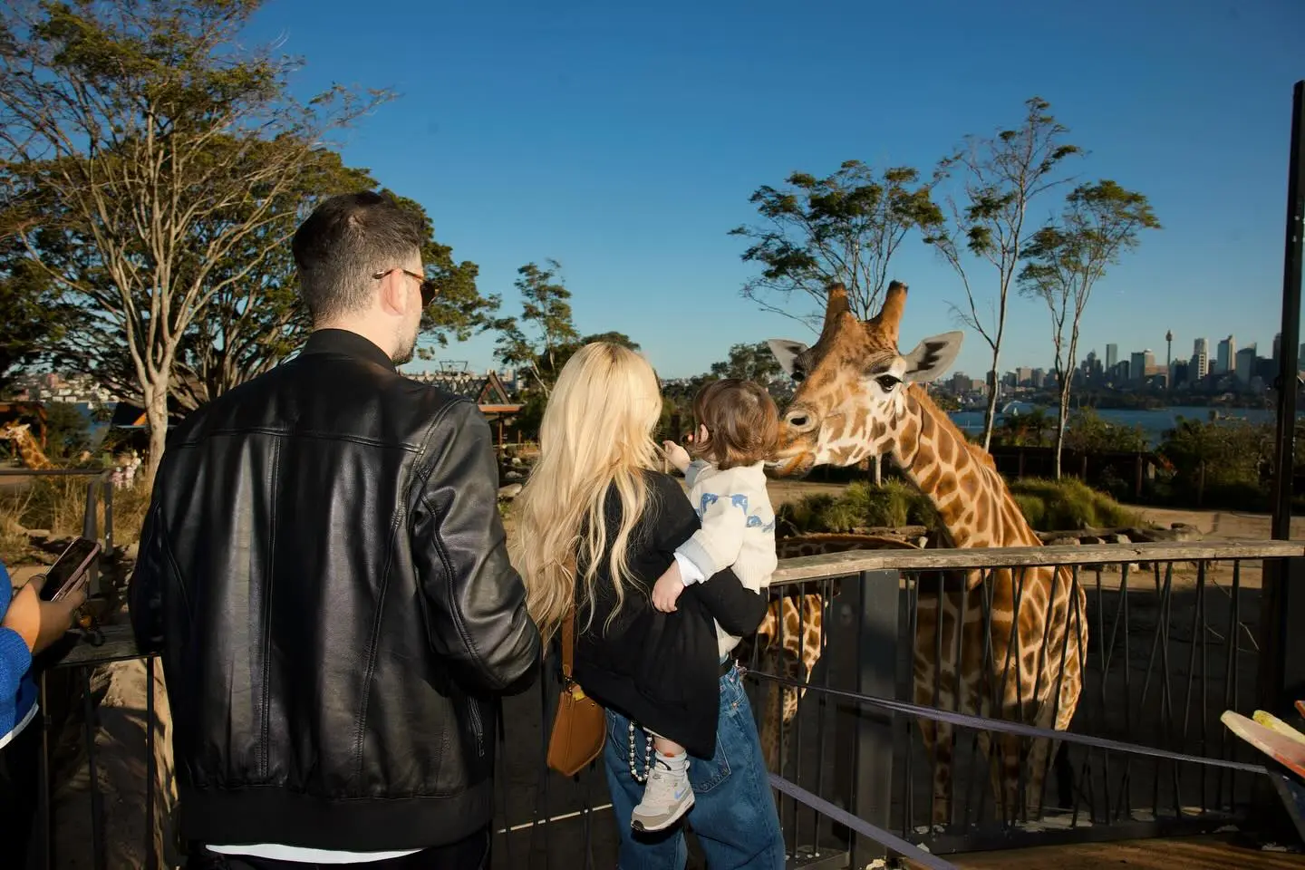 Lindsay Lohan and family watching a giraffe at Taronga Zoo in Sydney.