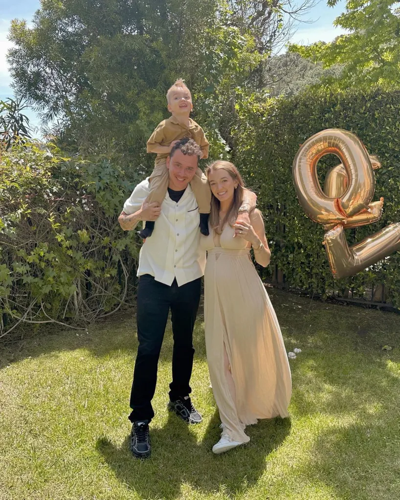 Logic and Brittney Noell with their son in a garden.