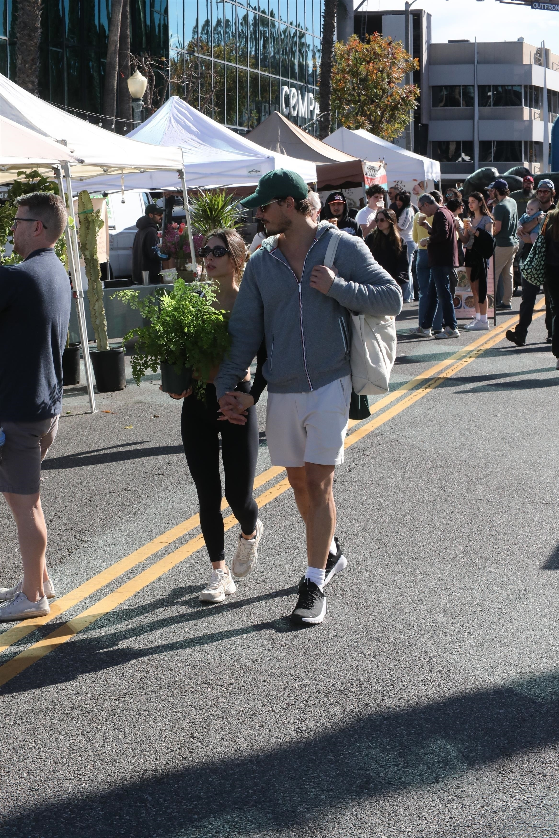 Gleb Savchenko and a mystery woman shopping for a plant at the Studio City farmers market.