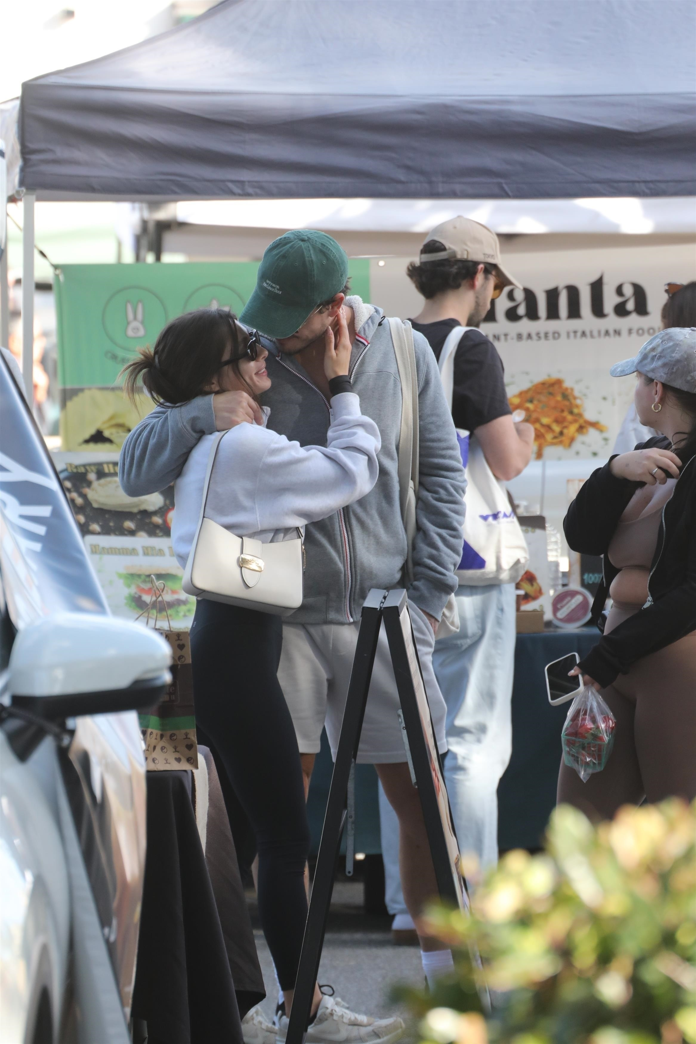 Gleb Savchenko and a mystery woman in a romantic embrace at a farmer's market.