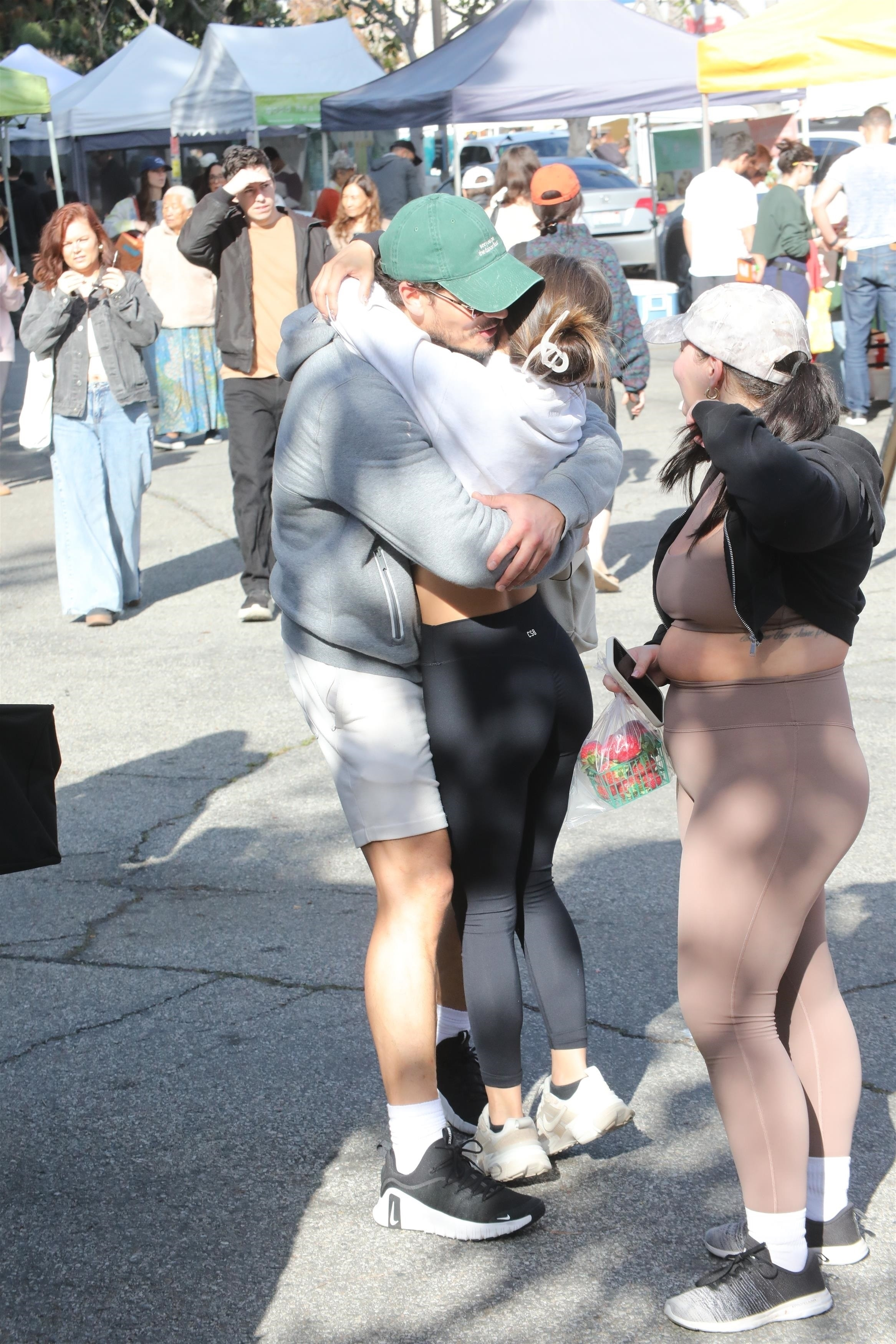 Gleb Savchenko hugging a woman at a farmers market.