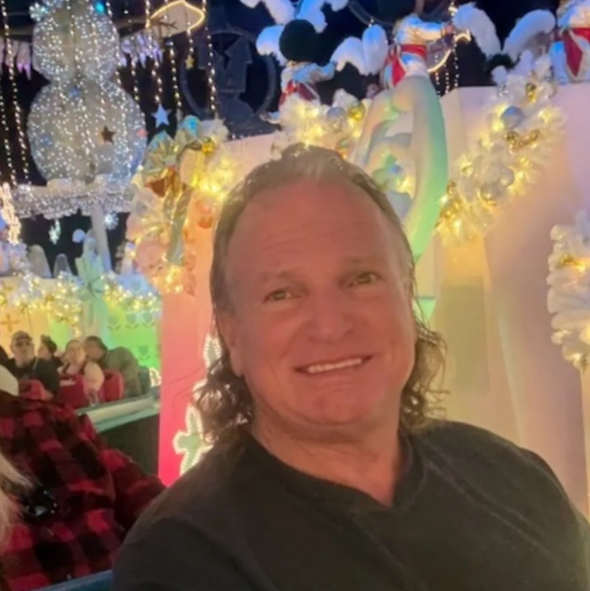 Luke Brugnara smiling in front of holiday decorations.